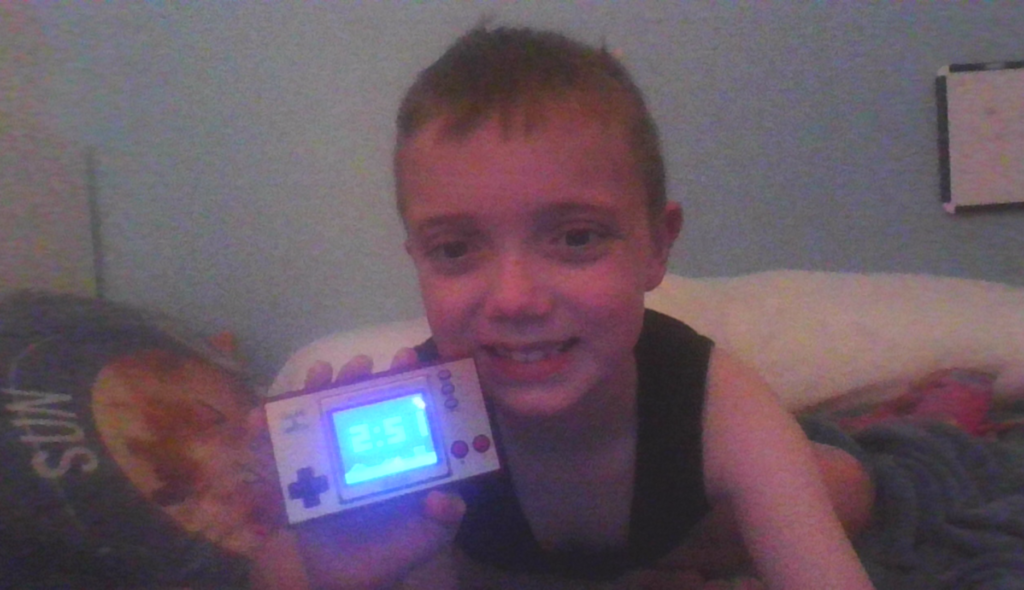 An image of connor harding holding the super mario brothers game and watch